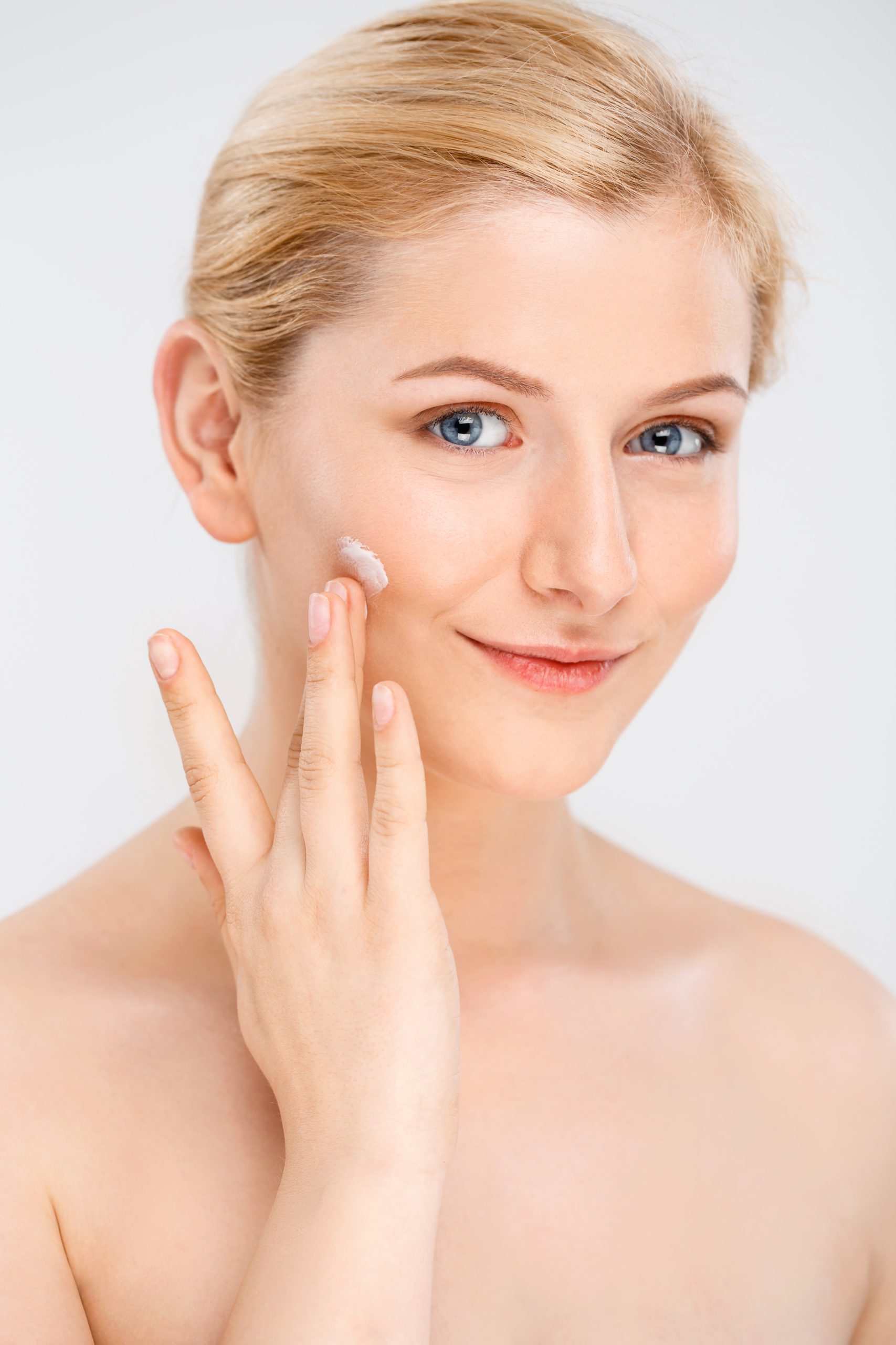 Woman applying facial cream as part of a professional skincare routine