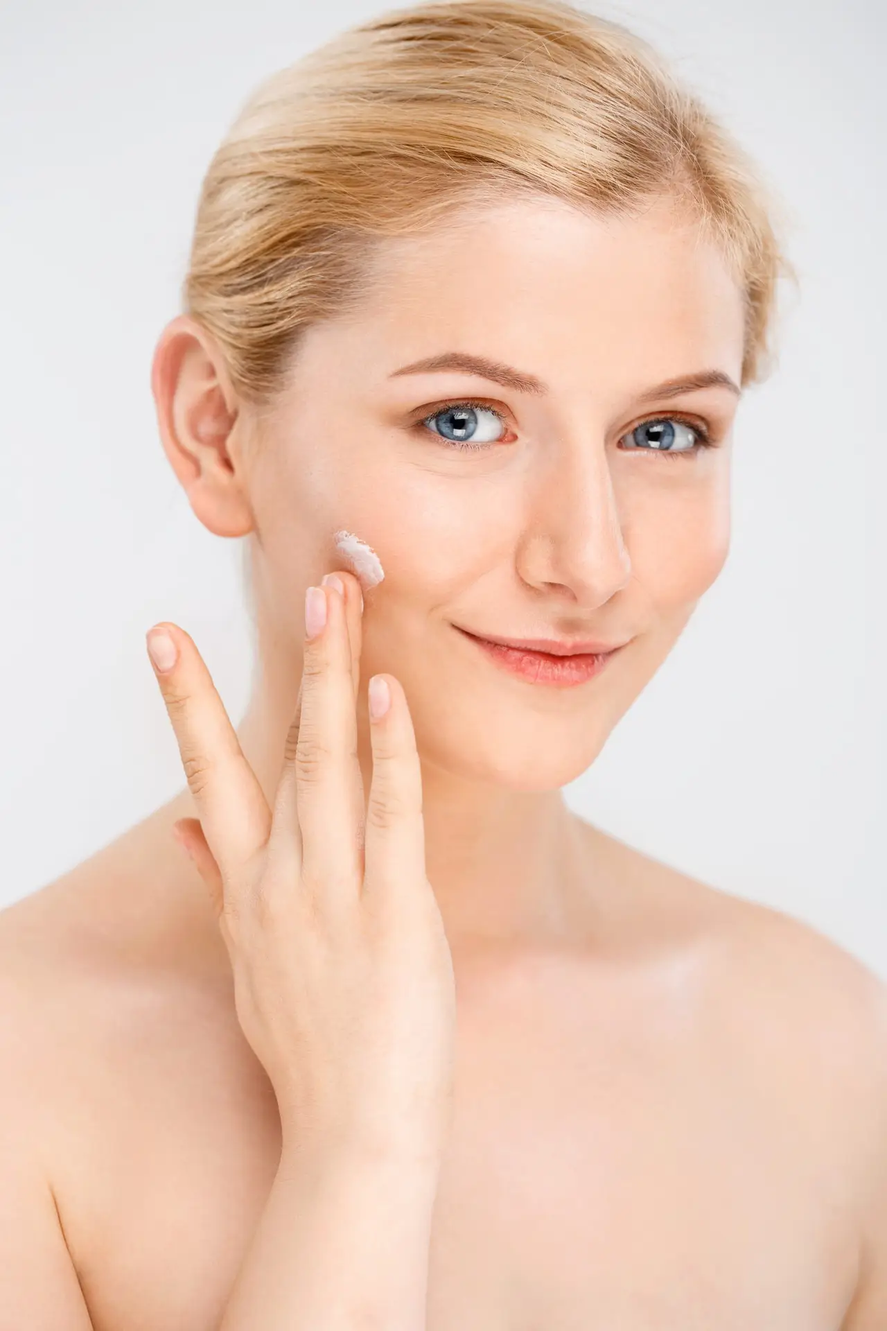 Woman applying facial moisturiser as part of her skincare routine